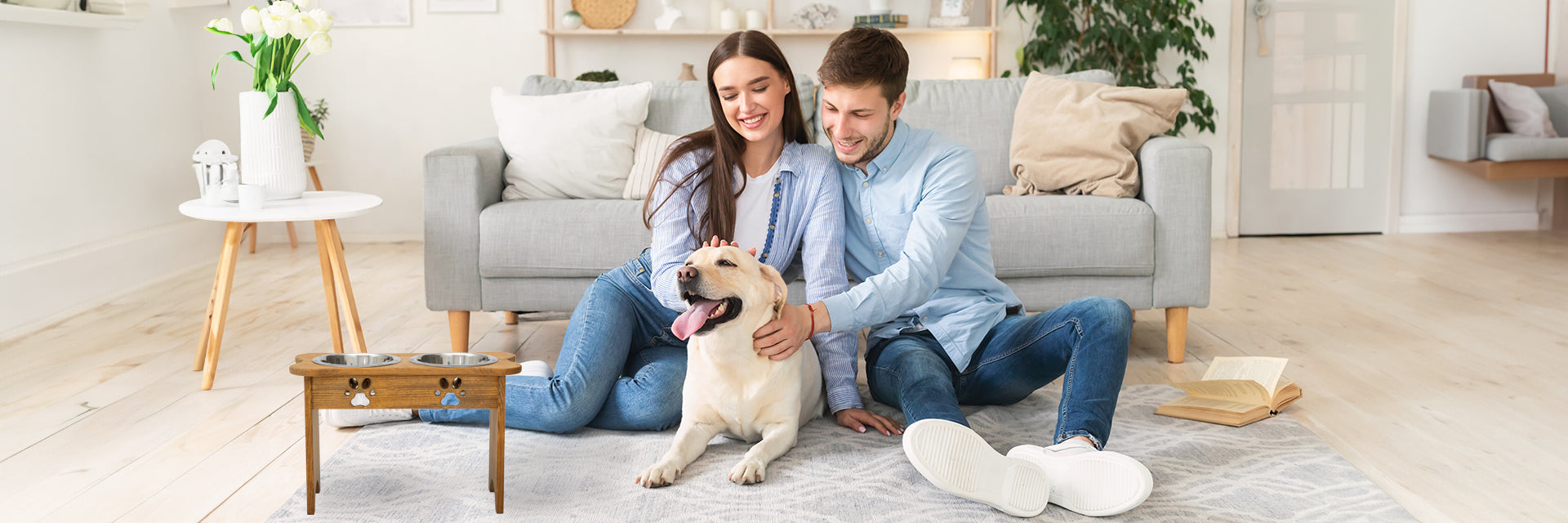 Couple in living room with dog and elevated dog feeder